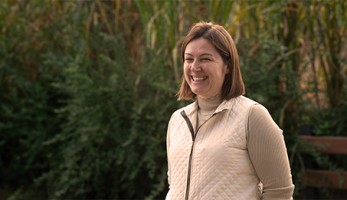 Mulher estudante Senar e-Tec sorrindo em uma plantação
